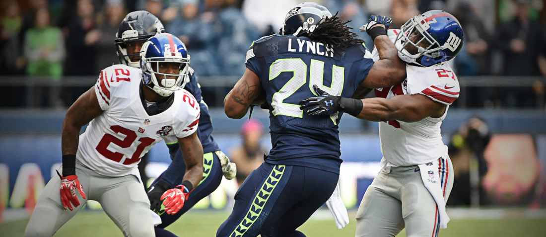 Marshawn Lynch throws up a stiff arm as he carries the ball versus the New York Giants